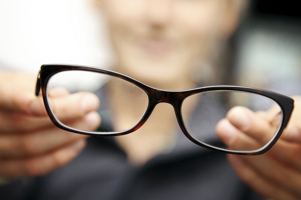 woman hands hold eyeglasses in front of her