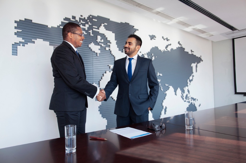 businessmen shaking hands at conference table picture id1140459829