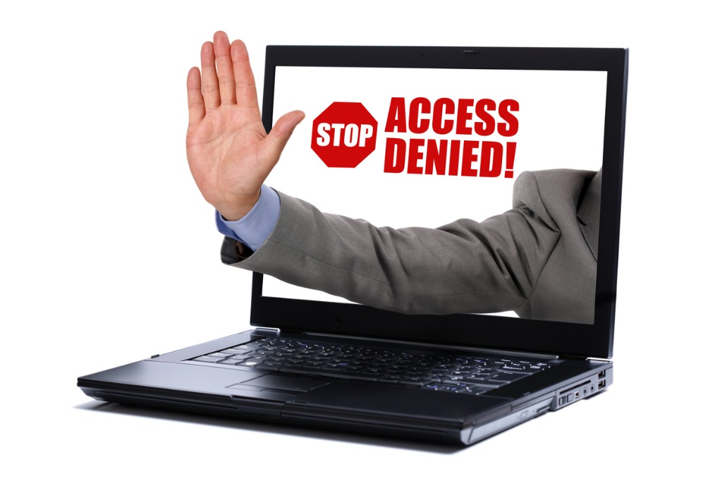 laptop showing a mans hand reading access denied picture id179036384 1