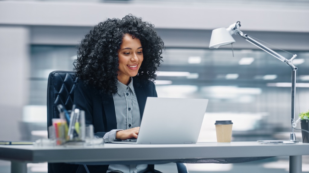 modern office black businesswoman sitting at her desk working on a picture id1365824279